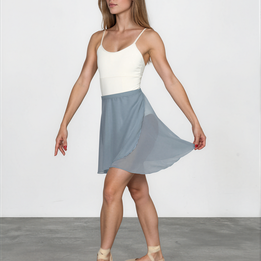 Woman wearing a white top and blue skirt on a plain background