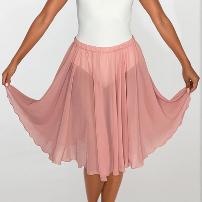 Woman wearing a white top and pink skirt on a plain background