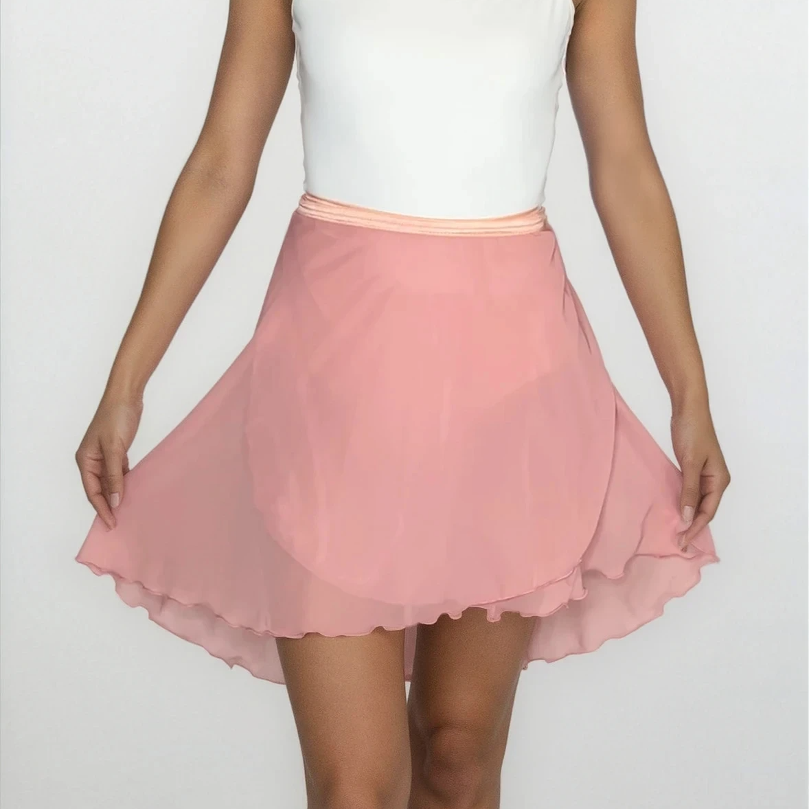 Woman wearing a white top and pink skirt on a white background