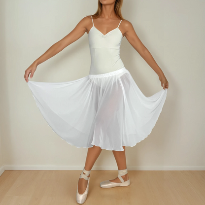 Woman in a white dress standing against a plain background